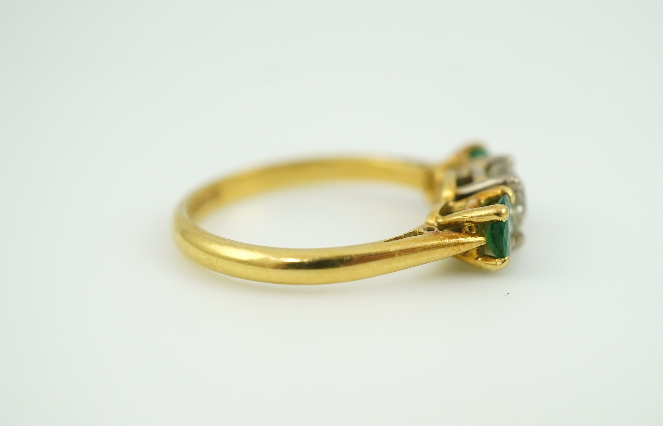 An emerald and diamond three-stone ring